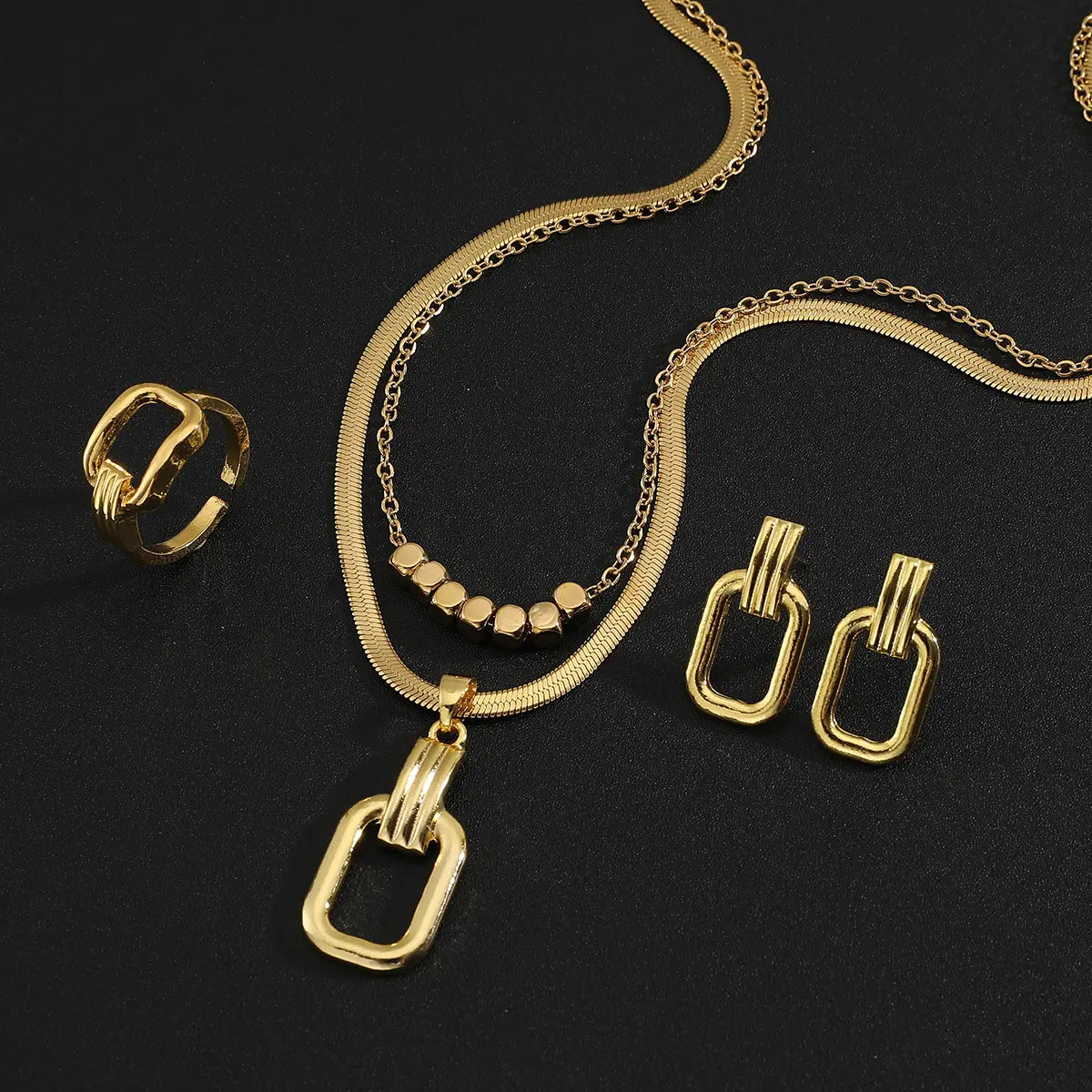 Collar de acero inoxidable color dorado para mujeres, con una cadena tipo serpiente de tono dorado y un dije rectangular con tres barras horizontales y una fila de pequeñas cuentas circulares.