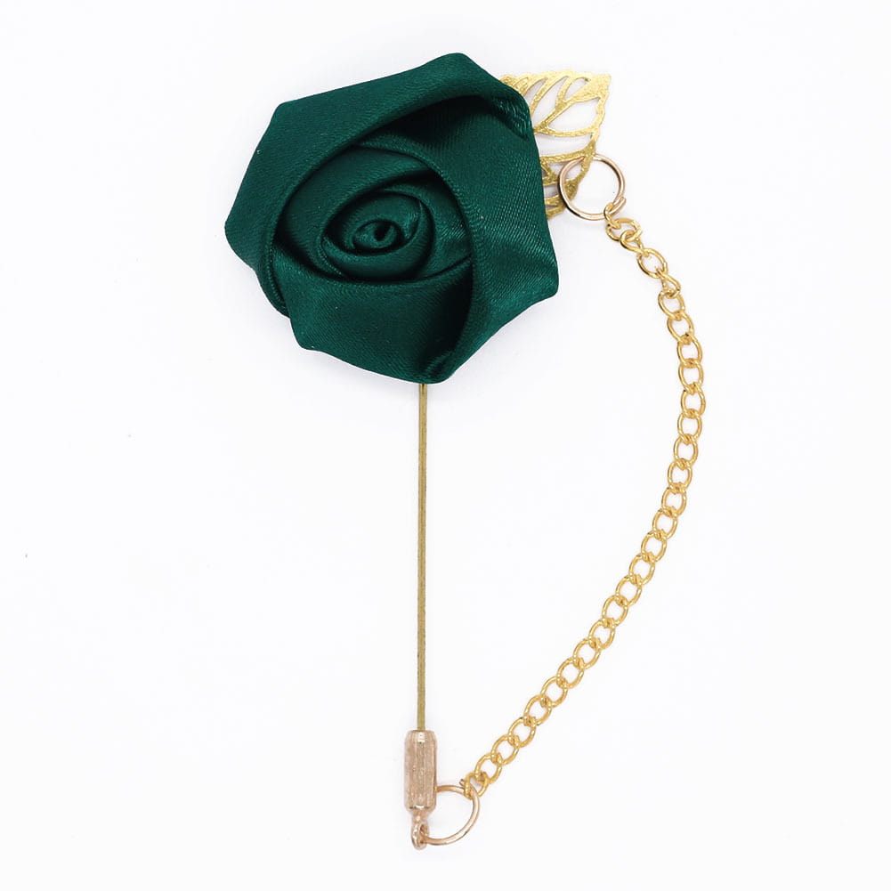 Boutonnière de rose bordeaux comportant une épingle de revers élégante en satin vert émeraude, avec une chaîne en métal à tons dorés et un accent feuillu.