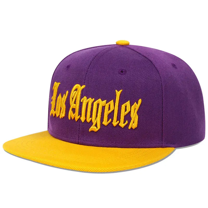Casquette snapback violette et or avec « Los Angeles » brodé en écriture jaune sur la partie avant.
