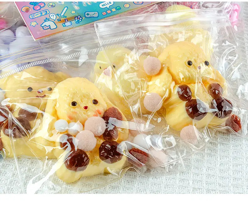 Ein gelbes Gummienten-förmiges niedliches Tier-Quetschspielzeug, gefertigt aus weichem Schaumstoff, mit pinken und braunen Bonbon-Akzenten, entworfen für sensorische Ablenkung und Stressabbau.