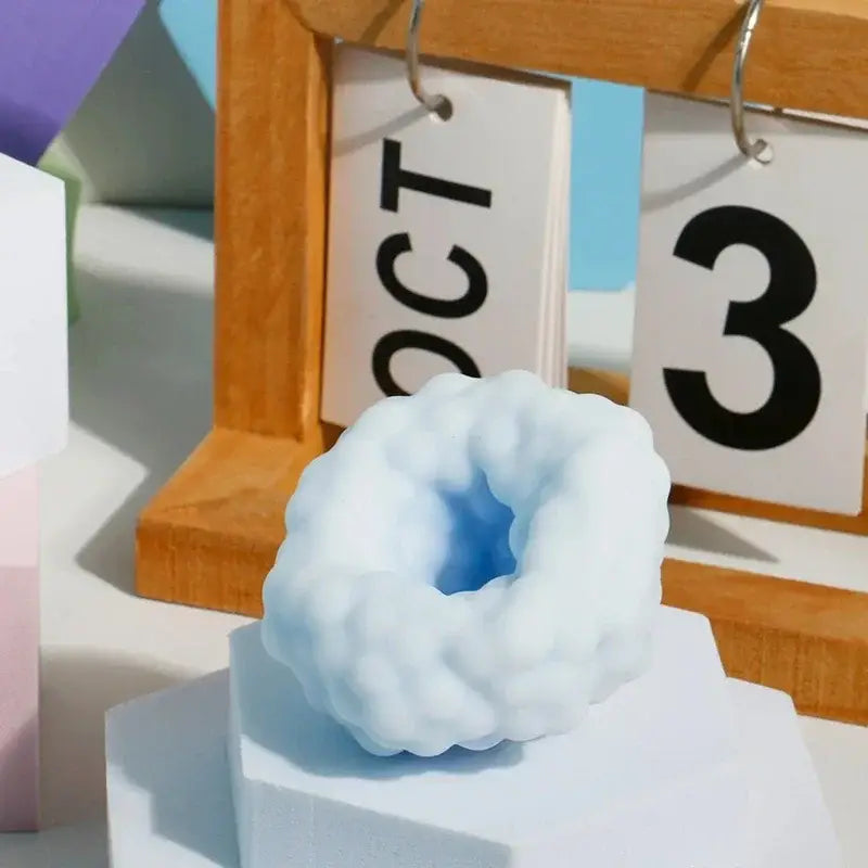 Ein hellblaues Stressball-Fidget-Spielzeug in Wolkenform mit strukturierter Oberfläche und einem hohlen Inneren, entworfen für die knisternd-sensorische ASMR-Anwendung.