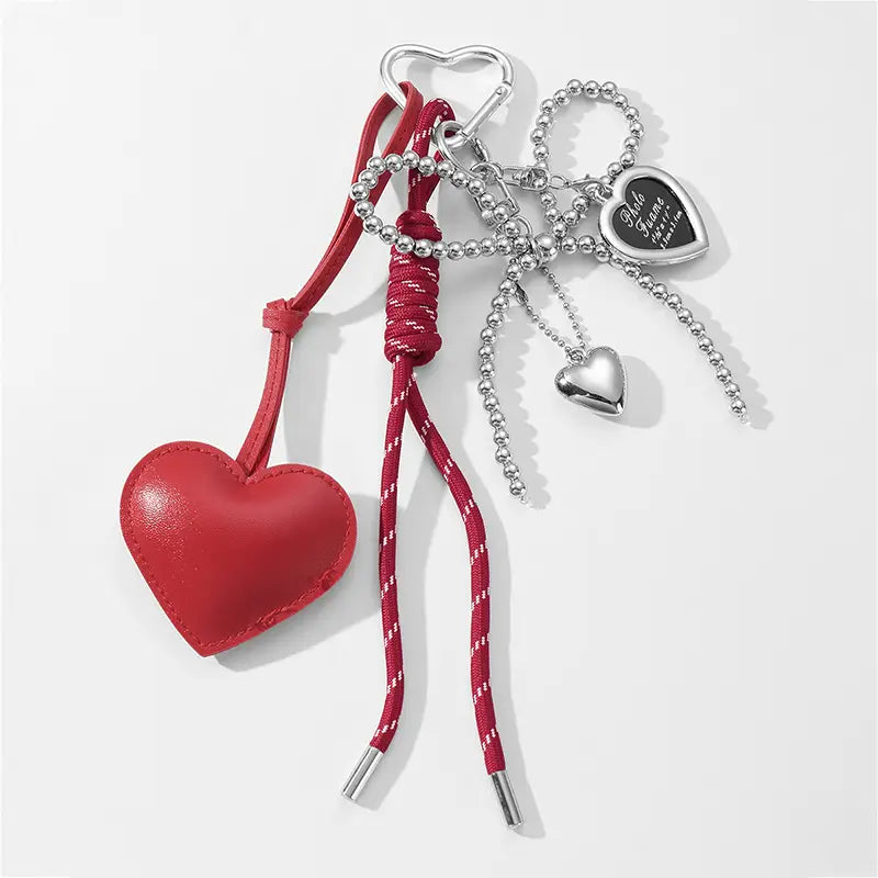 Red heart pendant bowknot bag keychain made of leather with silver-toned metal accents and a beaded chain.
