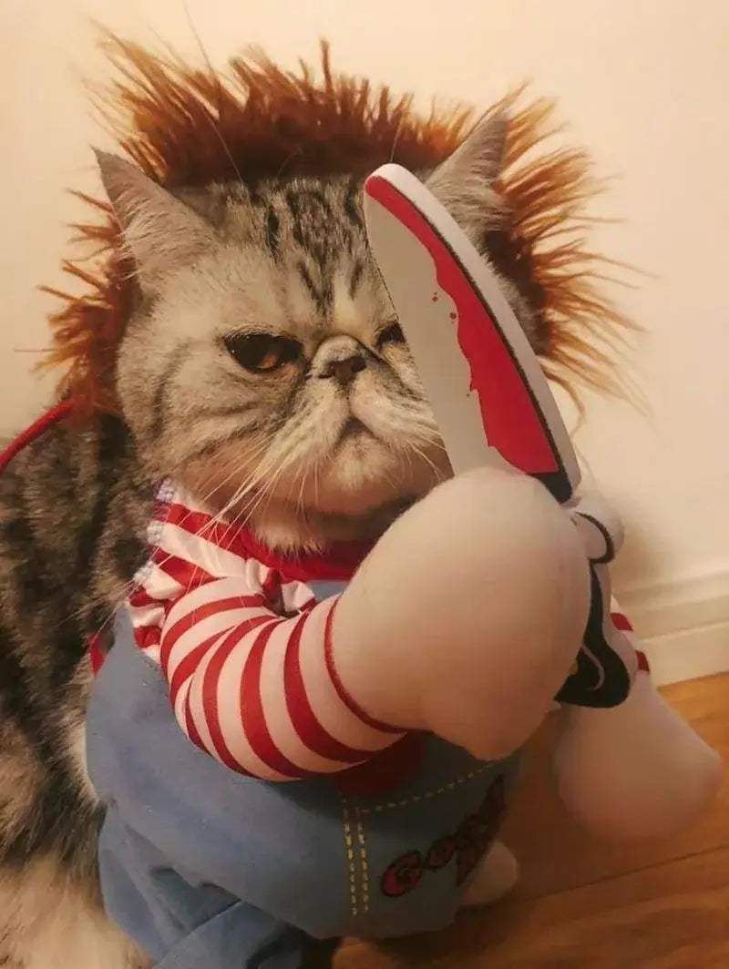 Un muñeco tipo chucky de peluche que lleva un disfraz divertido de perro con muñeco asesino, con una camisa de rayas rojas y blancas, un peto azul, cabello castaño erizado, una peluca y un cuchillo.