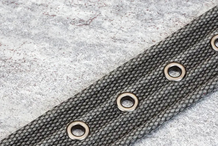 Ceinture pour homme en toile tissée avec boucle à épingle présentant une sangle en toile tissée gris foncé avec des œillets métalliques espacés uniformément.