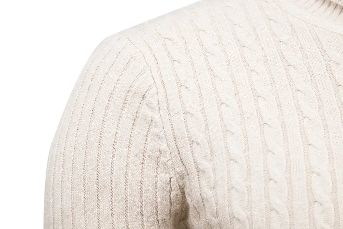 Men’s cream-colored cable knit turtleneck pullover sweater with a ribbed texture and high neckline.