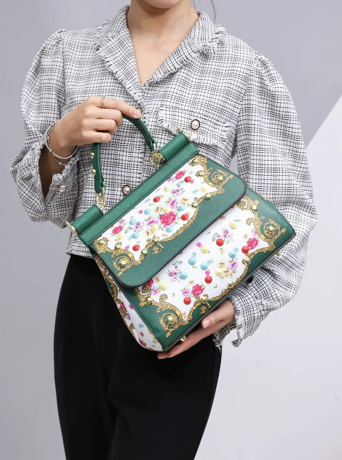 Sac bandoulière en cuir vintage, art raffiné, présentant un motif floral vert et blanc, avec des détails ornementaux dorés.