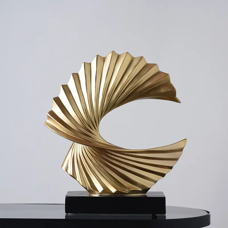 art deco gold wave sculpture is a golden metallic abstract tabletop decor with a swirling fan-like design on a black rectangular base
