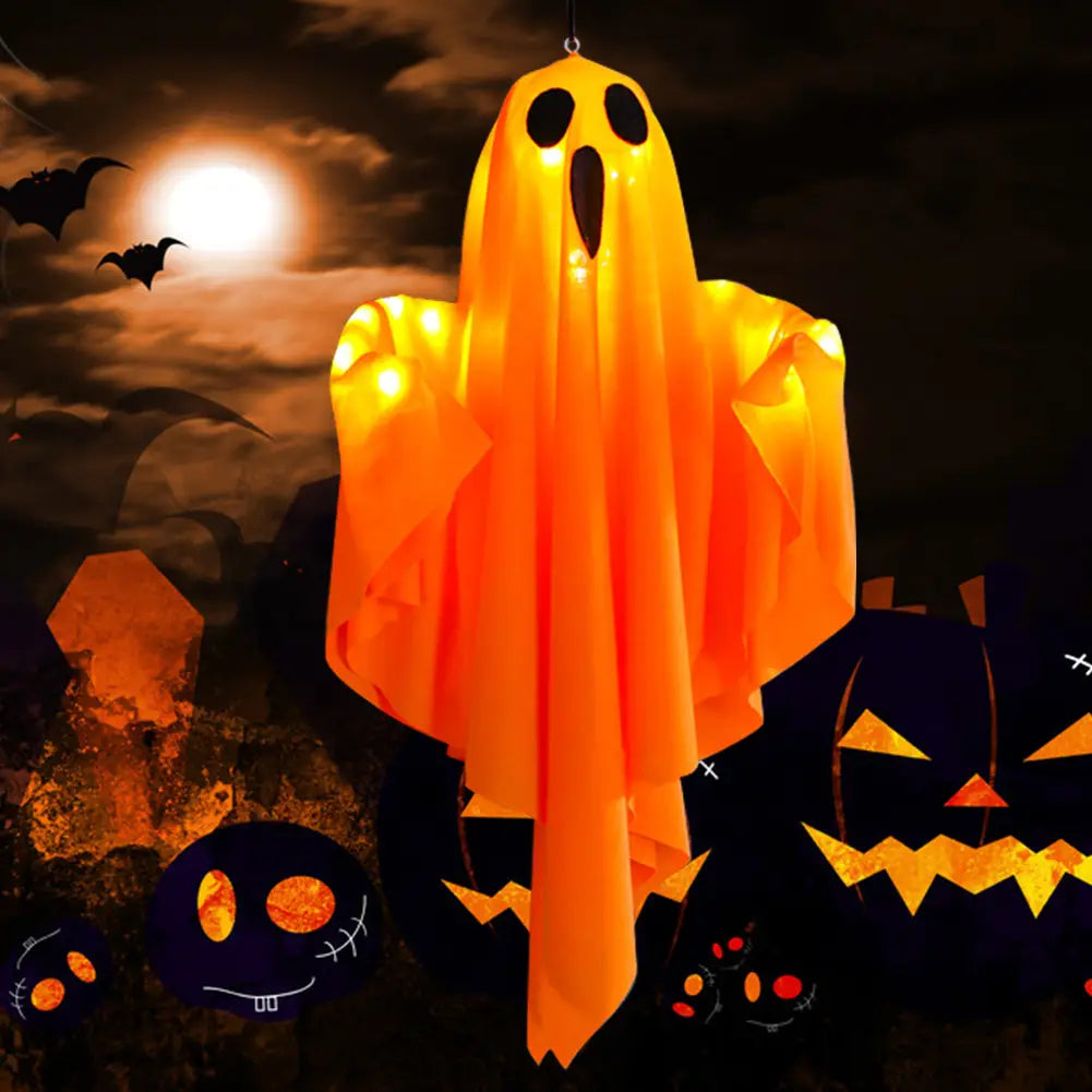 Led hanging ghost halloween decoration in glowing orange with black eye and mouth cutouts made of translucent material.