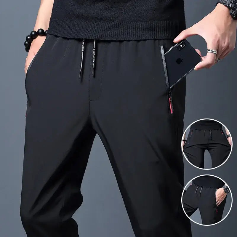Joggers casuales ajustados para hombre en tejido deportivo negro, con cinturilla con cordón, bolsillos laterales y un sutil logotipo blanco en los cordones.