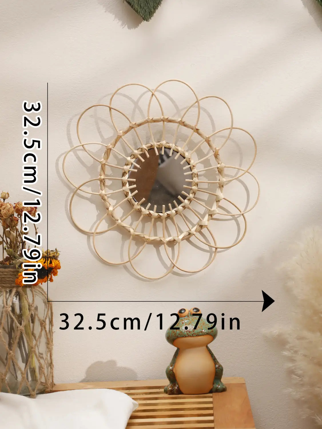 Ein runder Wandspiegel mit einem zarten, wie eine Sonnenblume wirkenden Rahmen aus hellfarbenem, gewebtem Rattan, der die ästhetische Gestaltung des Raums wirkungsvoll unterstreicht.