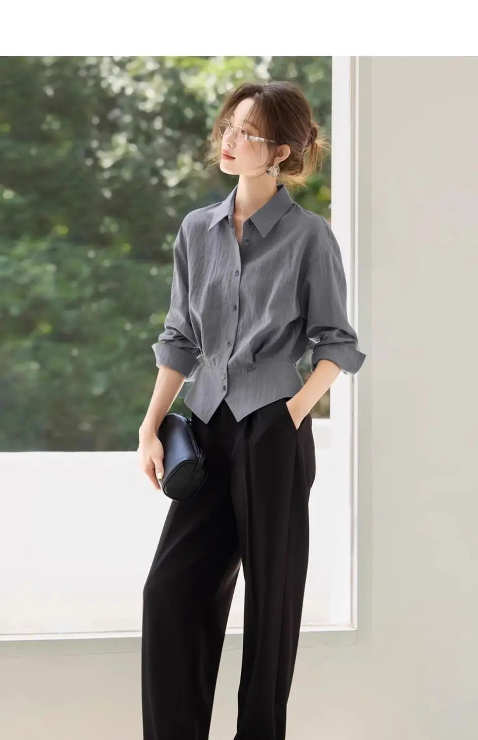 Chemise manches longues grise à manches retroussées et ourlet légèrement resserré, conçue comme une blouse de bureau ajustée pour femmes