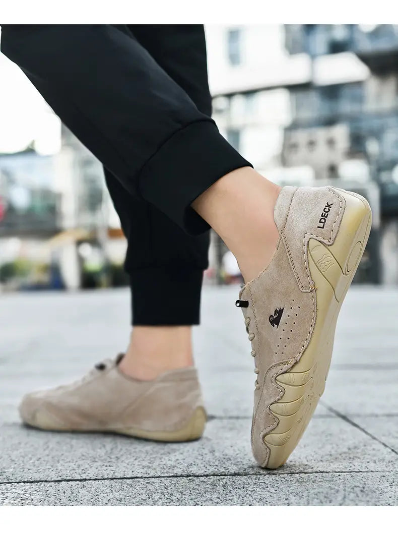 Men high top leather casual sneakers in beige suede with lace-up closure, subtle logo on the side, and textured stitching details.