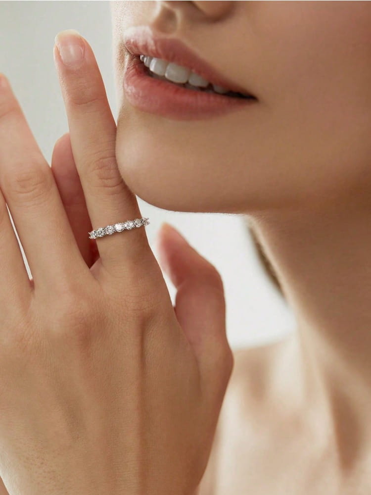 A delicate sterling silver band ring for women adorned with a row of sparkling zircon stones.