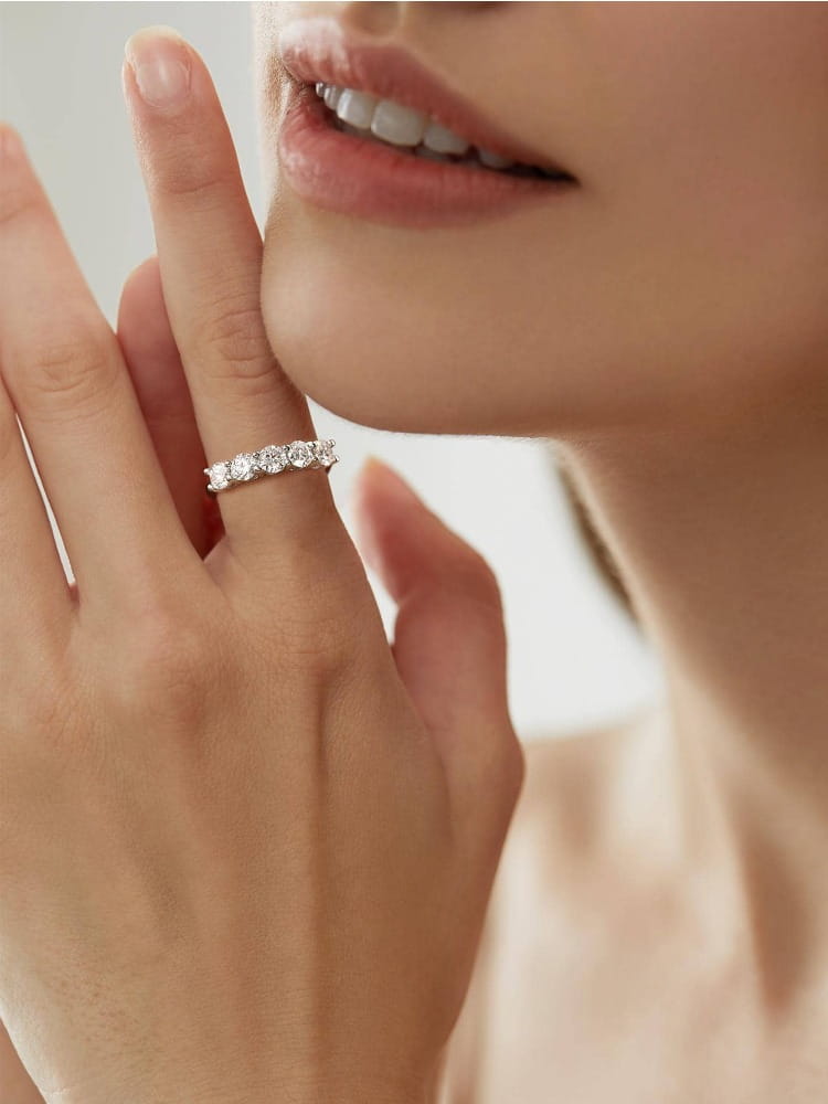A sterling silver zircon ring for women featuring a delicate silver band with five sparkling round-cut diamonds in a minimalist design.