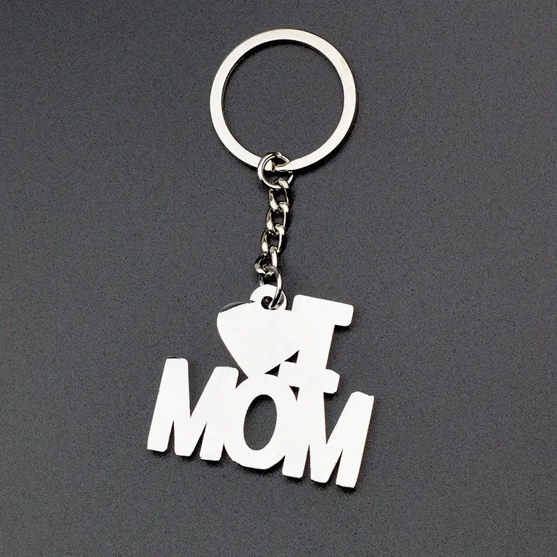 Silberner Metall-Schlüsselanhänger im Familienbuchstaben-Stil mit ausgeschnittenem Design und „I heart mom“ in kräftiger, stilisierter Schrift für ein Geschenkset für die Familie.