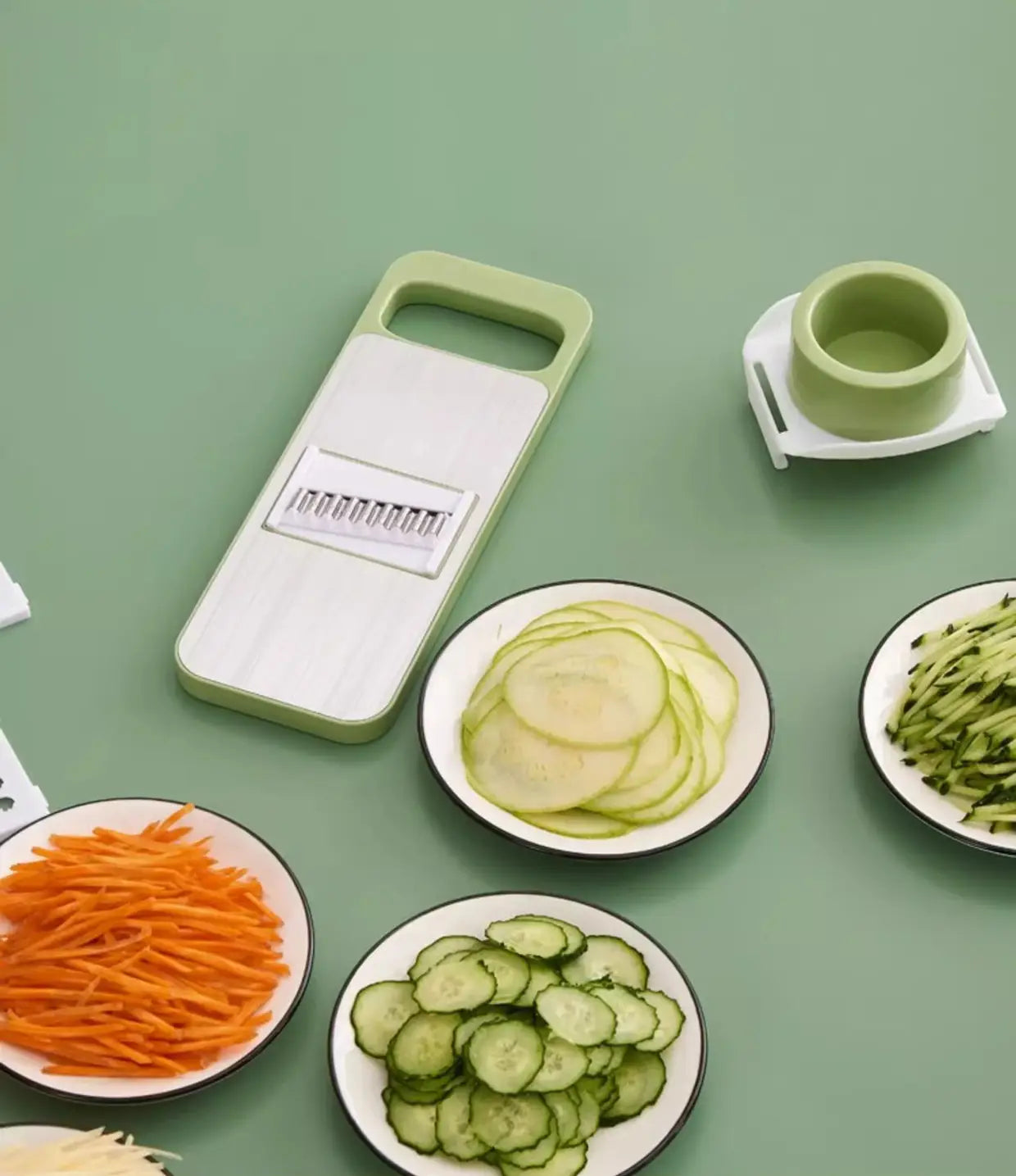 Light green and white multi-functional stainless steel vegetable slicer shredder with interchangeable blades for various cutting tasks.
