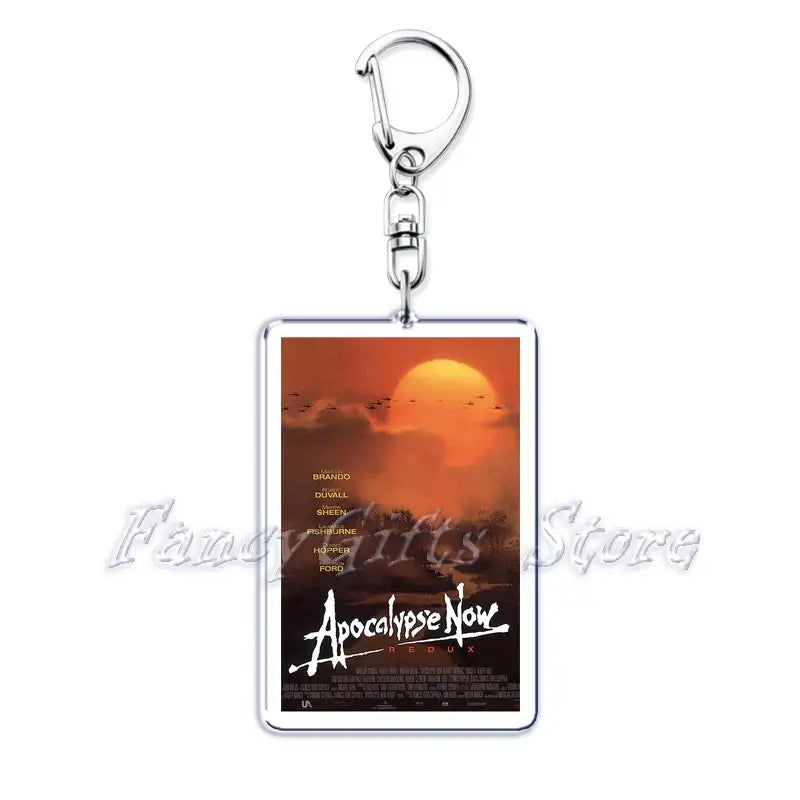 Silver rectangular acrylic keychain featuring the apocalypse now redux movie poster with a fiery orange sunset and black bird silhouettes from the movie poster acrylic keychain set.