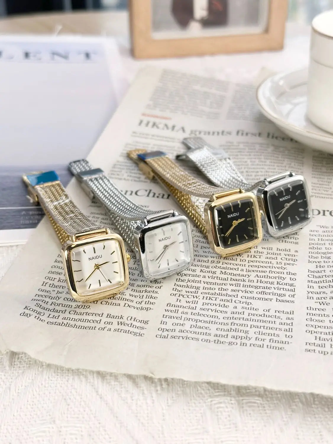 A collection of minimalist square quartz watches for women in gold and silver tones with mesh straps and elegant nadu square-faced dials.