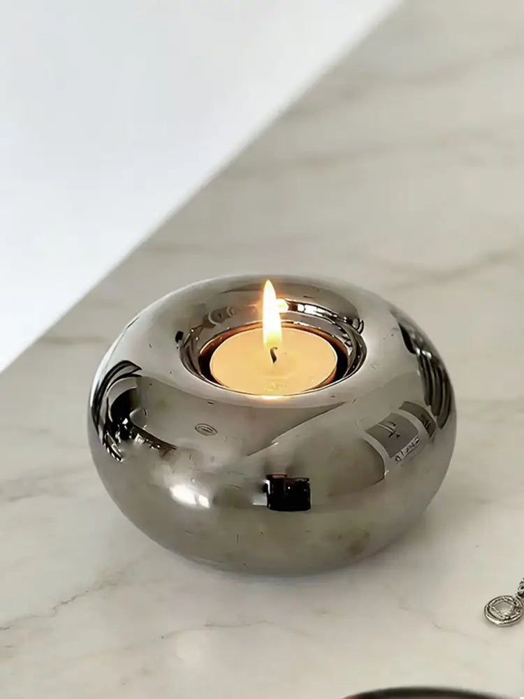Silver ceramic sphere candle holder with a shiny silver metallic finish featuring a smooth rounded design and reflective surface.