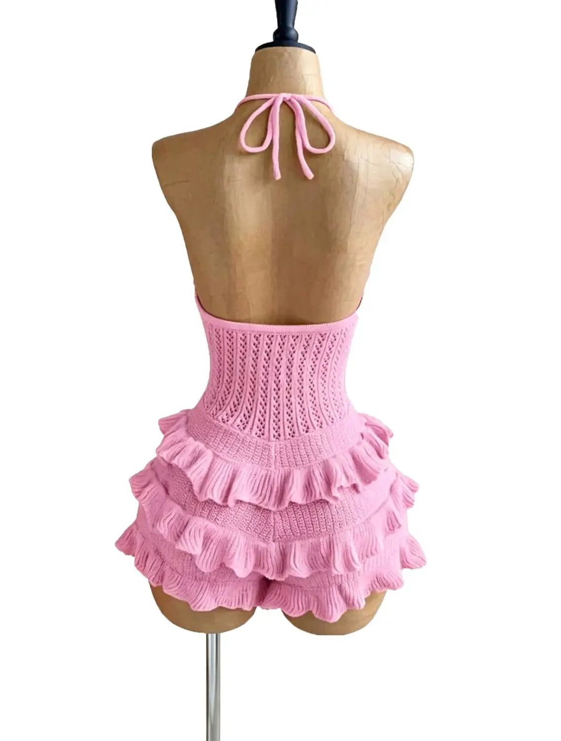A pink knitted ruffle halter romper summer playsuit featuring a ribbed waistband and layered ruffles.