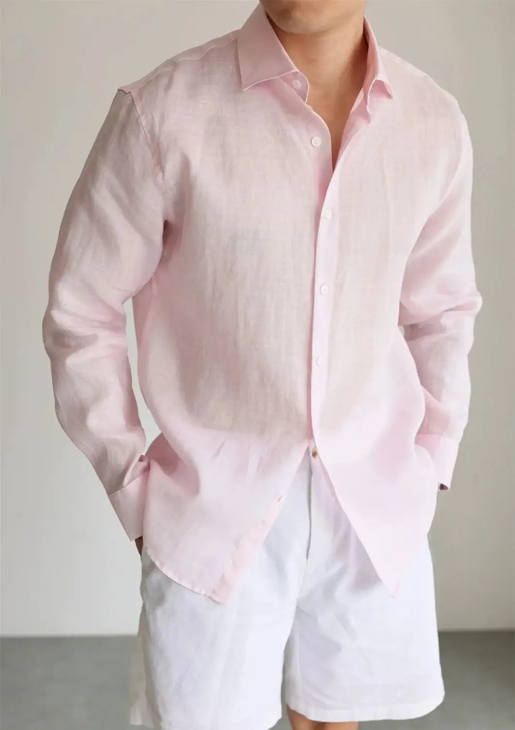A men cotton linen casual button down shirt in soft pink with a classic collar and long sleeves.