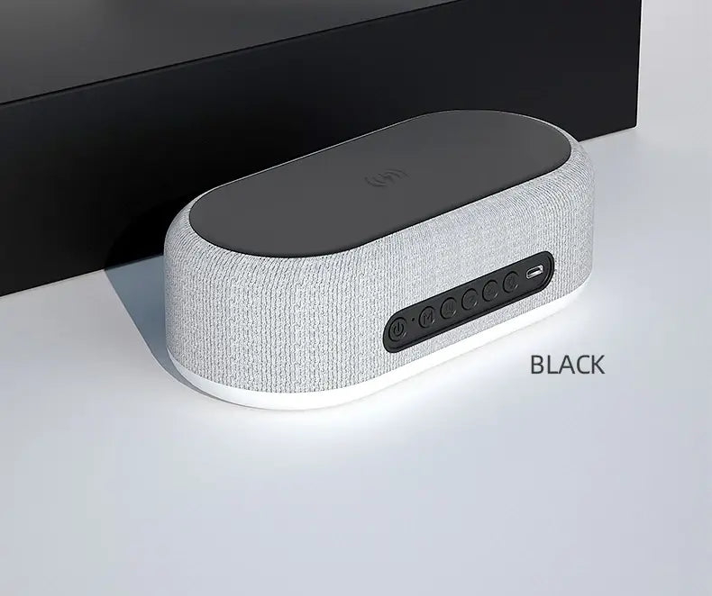 Haut-parleur Bluetooth en tissu texturé gris avec fonction de charge sans fil et mode d’économie d’énergie, doté d’un panneau supérieur noir, d’une base blanche et de boutons de commande sur le côté.