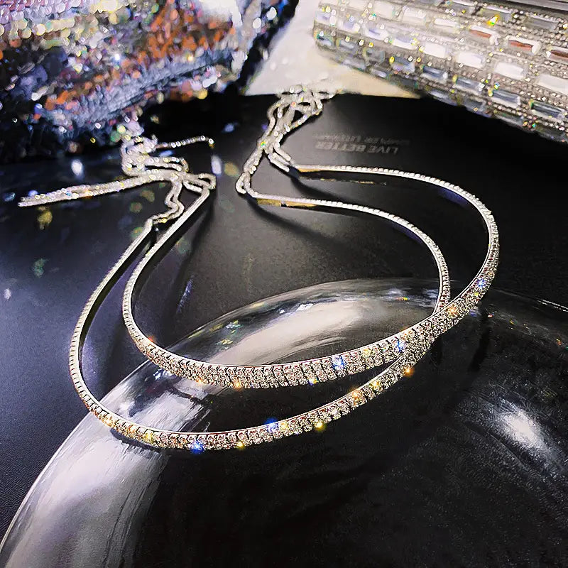 A sparkling silver crystal rhinestone tassel headband for women with a sleek curved design and embedded crystals.