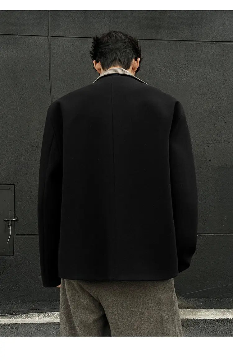 Blazer en laine noir avec un col à encoches discret et des épaules structurées, présenté comme faisant partie de la collection de vestes d’hiver en laine marron pour homme, coupe slim, col montant.