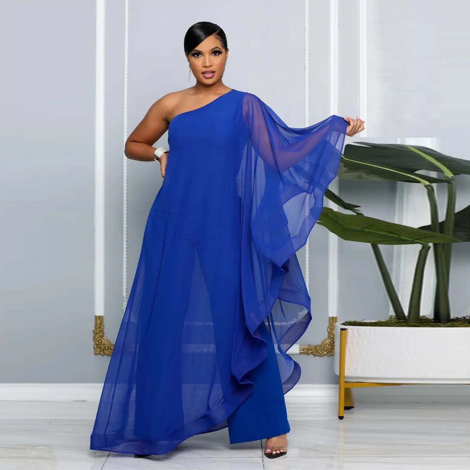 Ein leuchtend königsblaues Abendkleid mit einer Schulter aus fließendem Chiffonstoff, mit einem transparenten gerafften Überwurf, als eleganter Jumpsuit-Stil gestaltet.