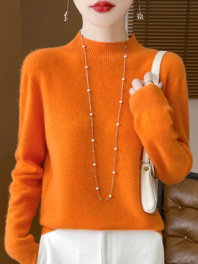 Vibrant orange merino wool pullover sweater for women featuring a soft-knit turtleneck with cozy texture and ribbed cuffs.
