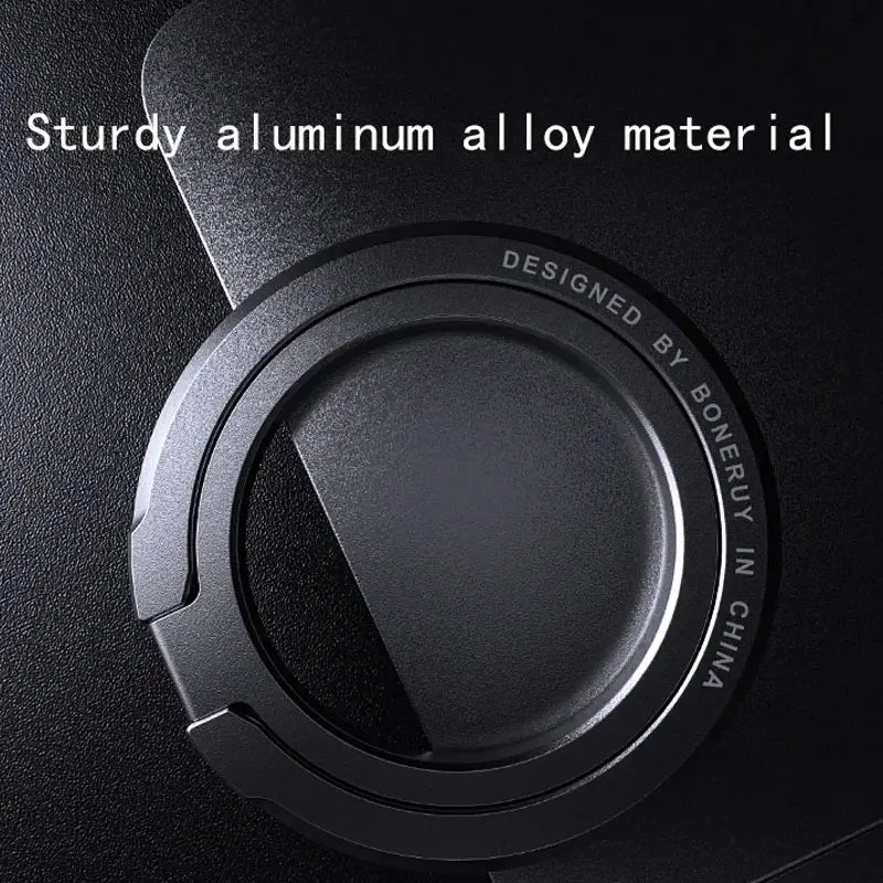 Base circular negra para anillo soporte magnético de teléfono, hecha de aleación de aluminio resistente, con un diseño minimalista y elegante para la compatibilidad con MagSafe.