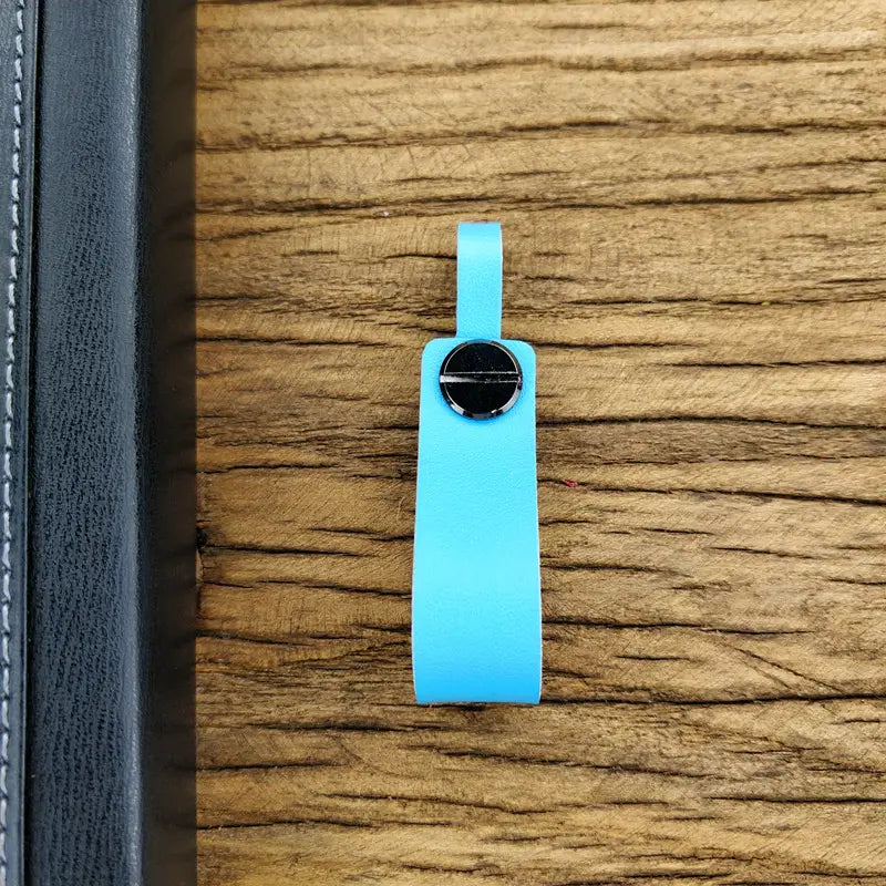 A sleek light blue genuine leather car keychain with a polished black circular metal key ring clasp.