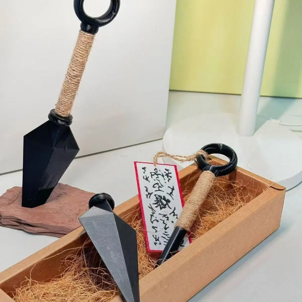 Ninja-Kunai-Kühlschrankmagnet mit einem schwarzen Shuriken mit seilumwickeltem Griff und einer aus PVC bestehenden, metallisch wirkenden Klinge als Spielzeug.