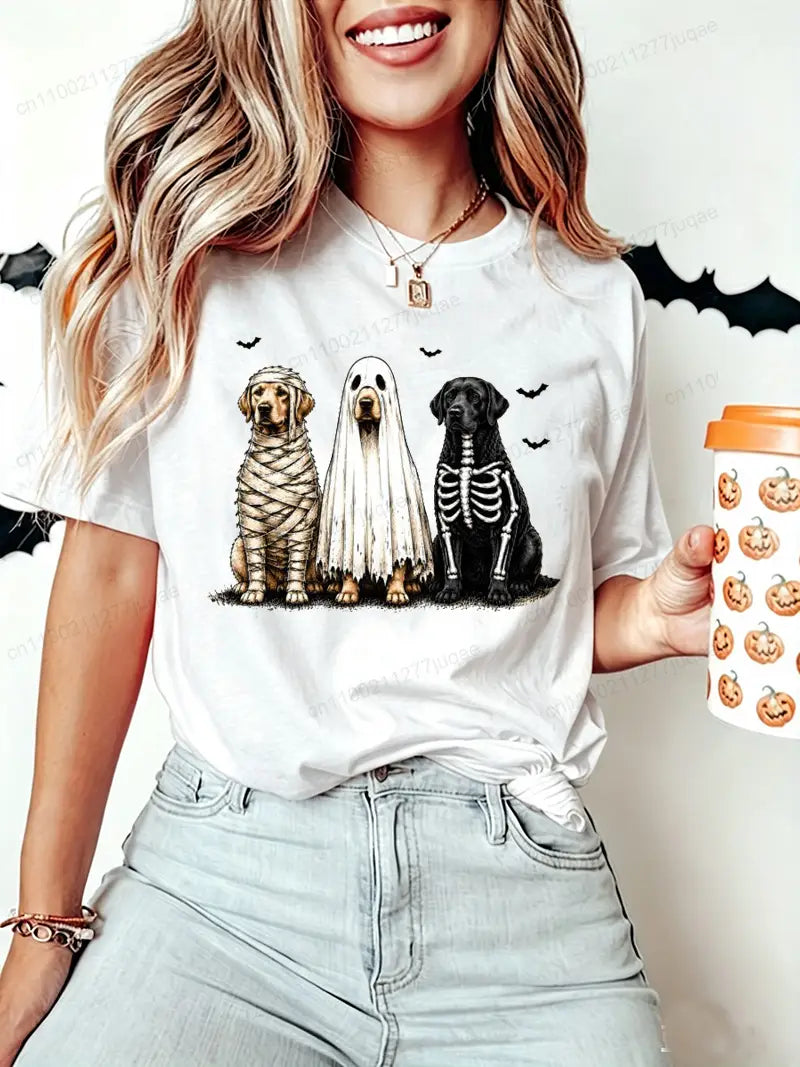 White short sleeve women’s t-shirt featuring a halloween-themed graphic of three dogs dressed as a mummy ghost and skeleton.