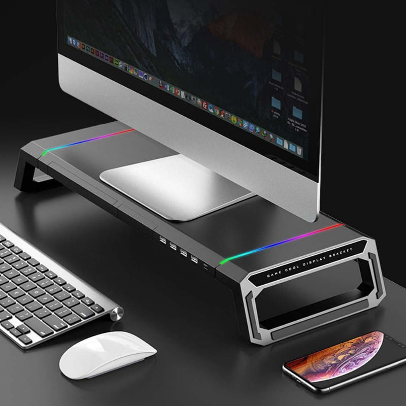 Support de moniteur RGB noir et argent avec station d’accueil USB et tiroir de rangement, doté d’un éclairage RGB le long de ses bords.