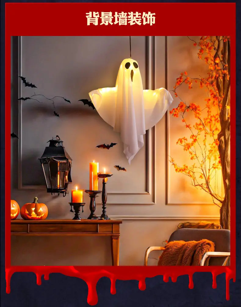Décoration d’Halloween présentant une silhouette de fantôme blanc suspendue lumineuse, fabriquée en tissu translucide, avec des découpes pour les yeux et la bouche noirs.