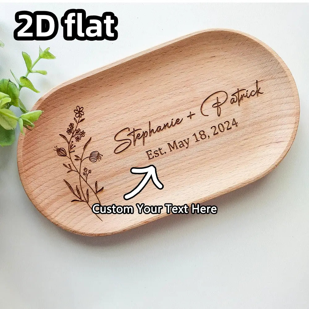 Petit plat ovale en bois brun clair avec un décor floral gravé et des noms personnalisés pour un souvenir de couple.