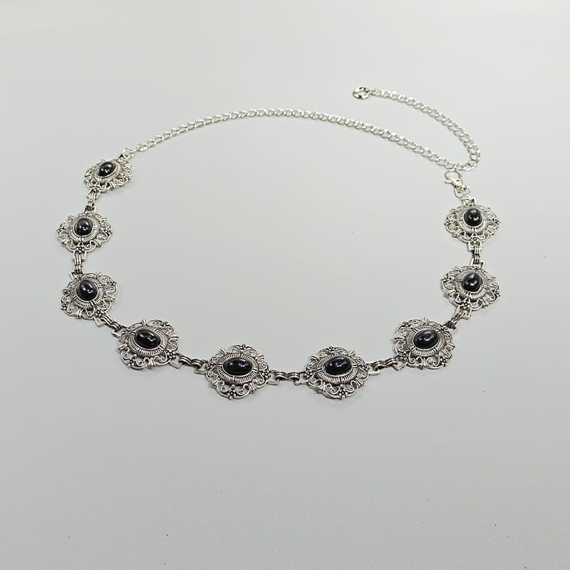 Ceinture de hanche en chaîne argentée pour cosplay, avec des maillons floraux ornés et des pierres ovales noires, conçue comme accessoire de ceinture de hanche pour femme, dans un style gothique punk