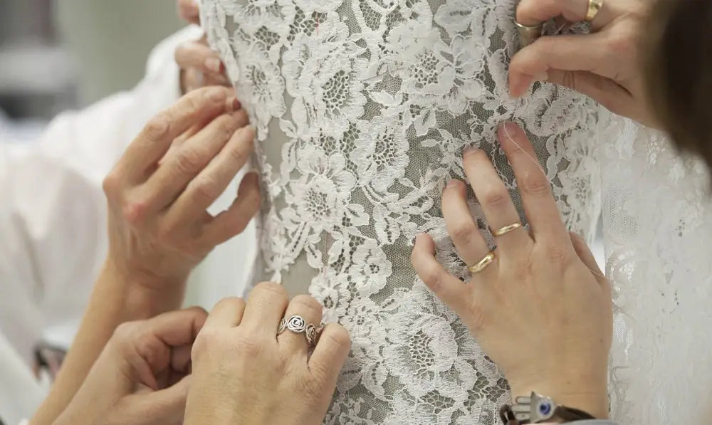 Weißes florales Spitzen-Hochzeitskleid mit kunstvollen Details in einem maßgeschneiderten trägerlosen A-Linien-Satinbodenlangen Design