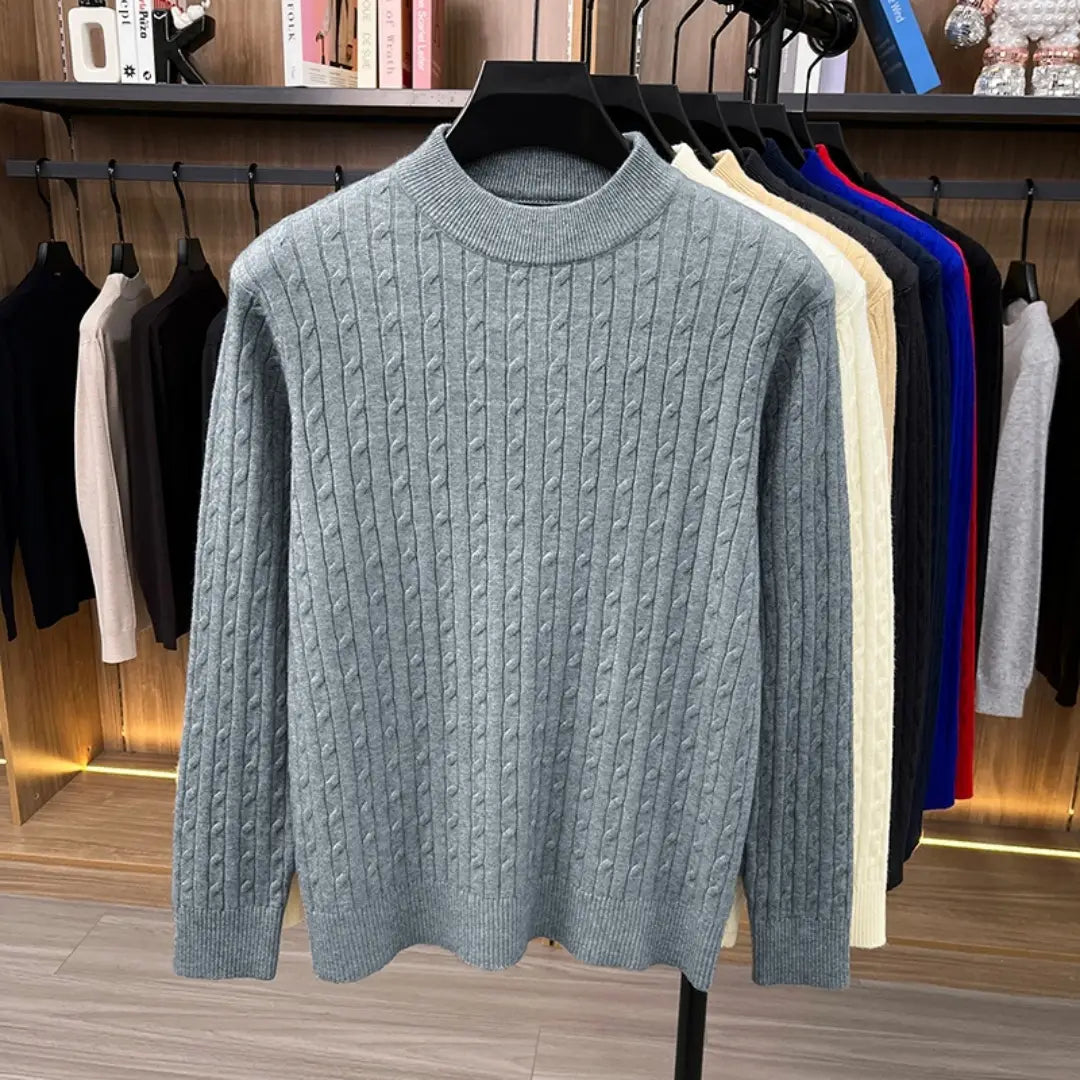 Herren-Zopfstrick-Pullover mit Rundhalsausschnitt in Hellgrau mit geripptem Rundhalsausschnitt und Bündchen, dargestellt auf einem schwarzen Kleiderbügel.
