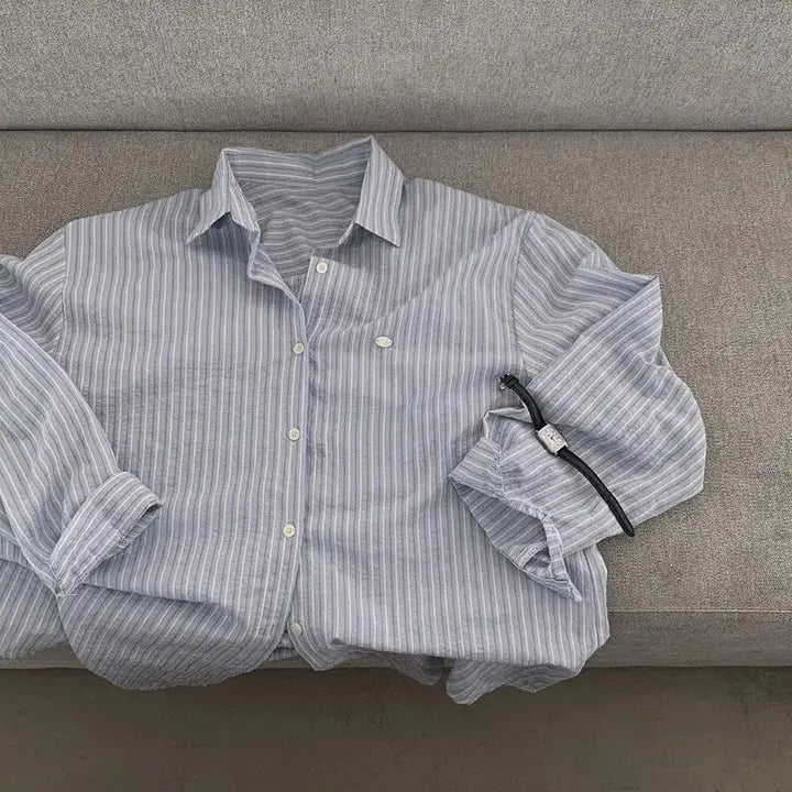 Striped long sleeve button down shirt featuring a versatile style with a light blue and white striped pattern, made of soft cotton fabric with standard thickness and a relaxed fit.