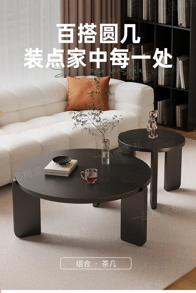 Moderner schwarzer runder Couchtisch mit elegantem minimalistischem Design und robusten geometrischen Beinen, die die wichtigsten Verkaufsargumente für zeitgemäße Wohnbereiche hervorheben.