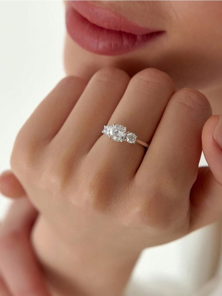 A delicate sterling silver zircon ring for women featuring a rose gold finish and three sparkling diamonds in an elegant trio setting.
