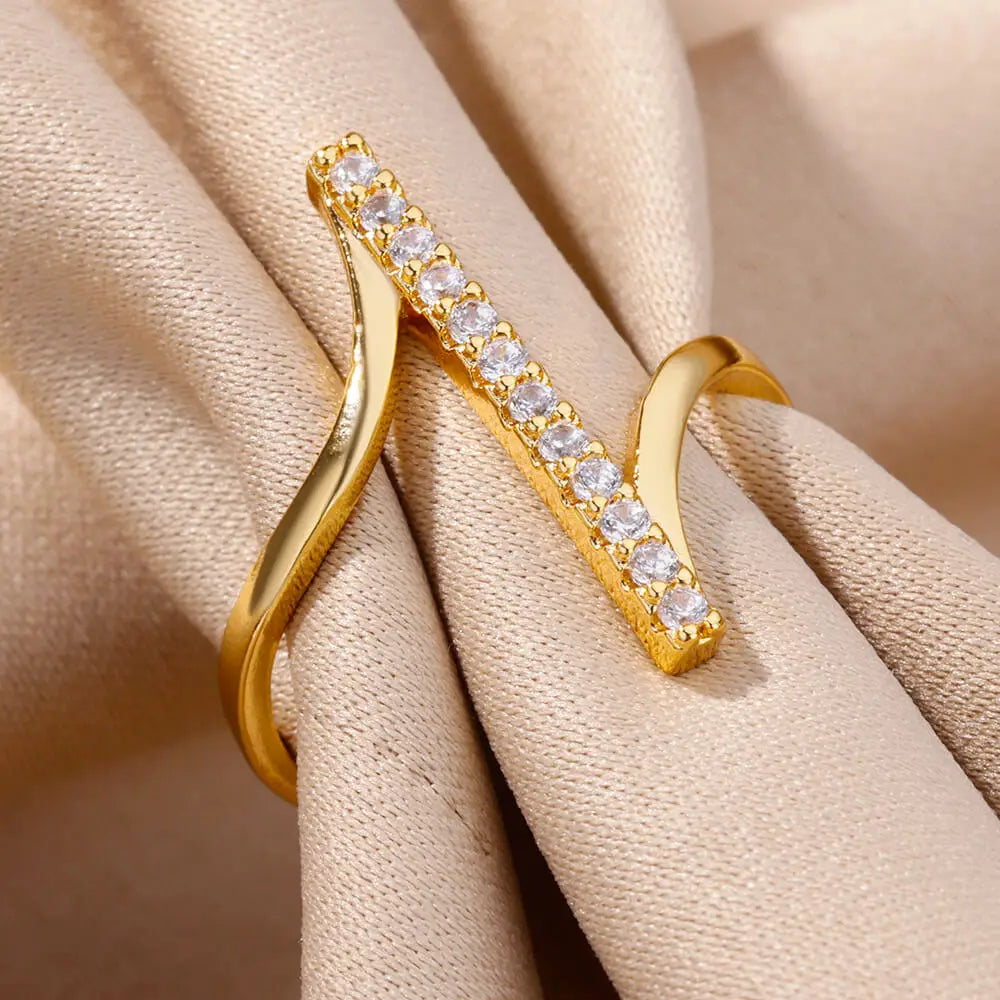 Gold-toned women gold color stainless steel ring with a sleek twisted band and a central bar adorned with clear zircon geometric rings.