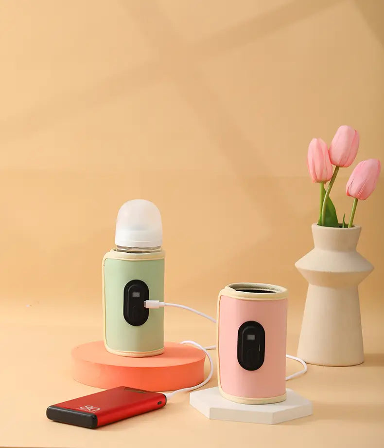 Tragbare USB-Babyflaschenwärmer in Pastellgrün und -pink mit schwarzen Bedienfeldern, ausgelegt für eine bequeme elektrische Erwärmung von Babyflaschen.