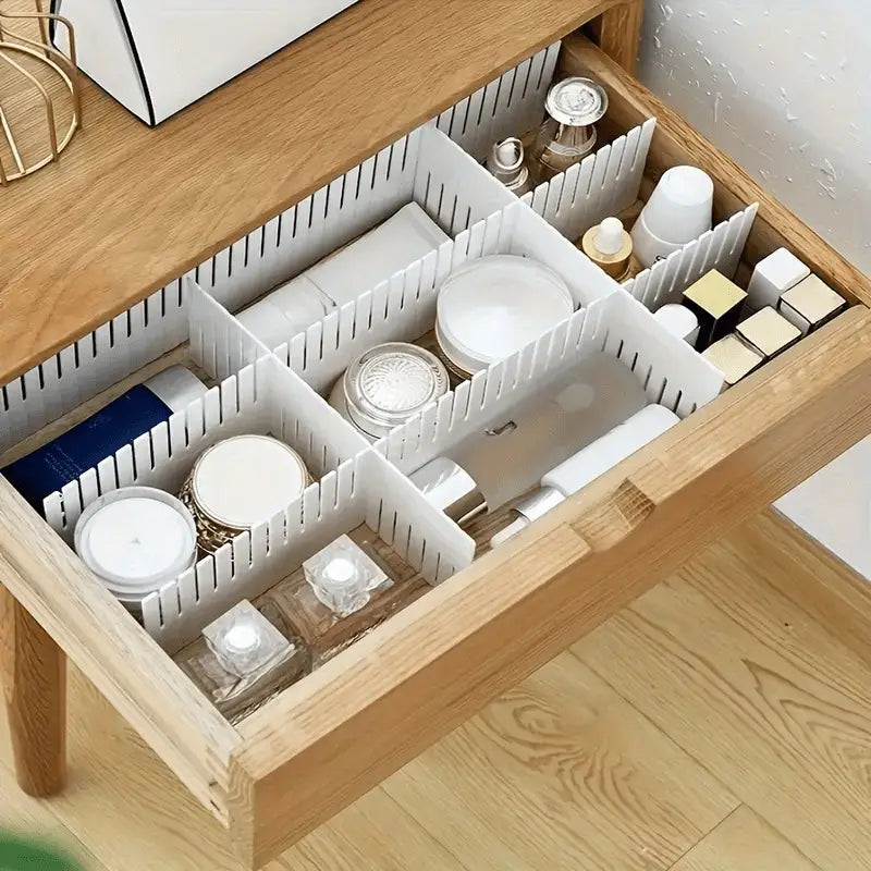 adjustable white plastic drawer divider partition with vertical slats organizing cosmetics and skincare items