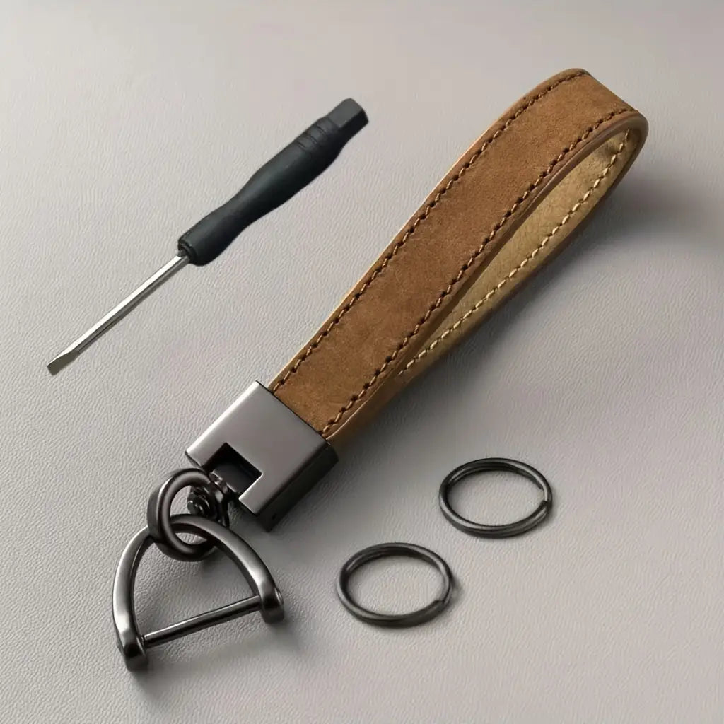 Leather car keychain minimalist key ring in tan suede leather with a matte black metal clasp and d-ring featuring contrasting light-colored stitching.