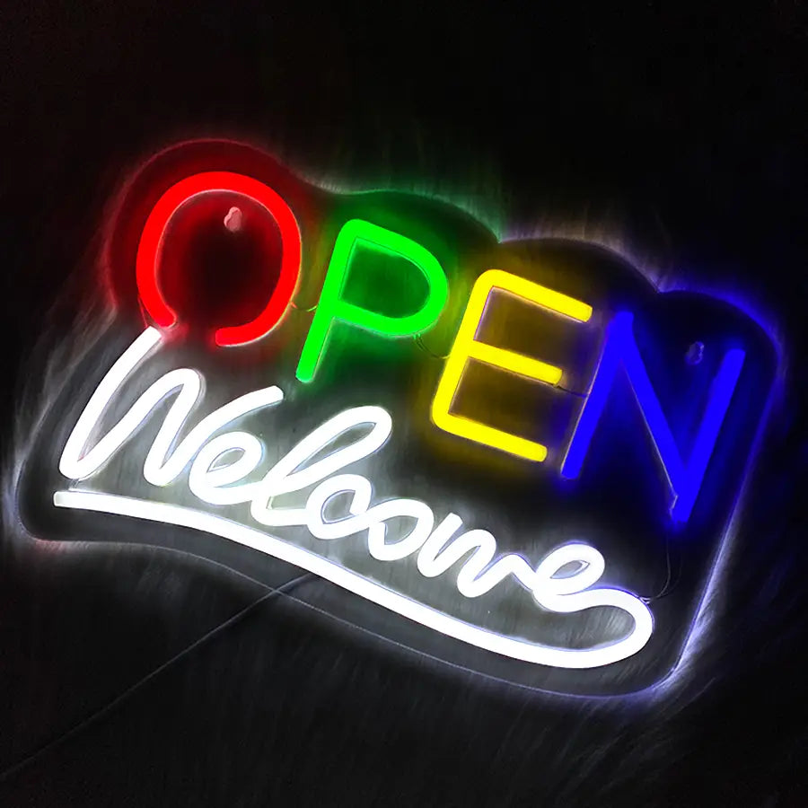 Une enseigne néon vibrante de couleur arc-en-ciel, alimentée par USB, affichant « ouvert » en lettres grasses et « bienvenue » dans un écoulement de script en dessous.