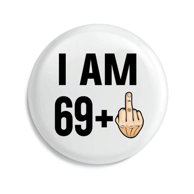 badge de broche émaillé circulaire blanc avec du texte noir indiquant « j’ai 69 ans et plus » et une main dessinée effectuant un geste obscène, conçu comme un cadeau amusant d’anniversaire marquant une étape d’âge.