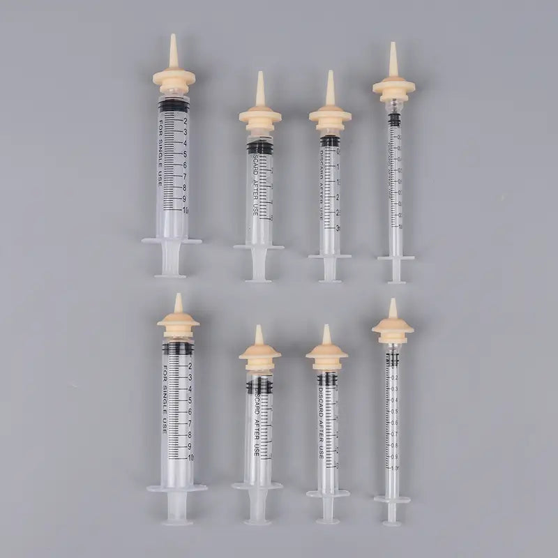 clear plastic medical syringes with beige caps and black measurement markings in 3ml 5ml 10ml sizes are part of a pet feeding syringe set with silicone nipple for precise feeding.